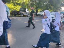 Rutinitas Babinsa Bantimurung Bantu Anak Sekolah Menyebrang Jalan Guna Mencegah Terjadinya Lakalalin